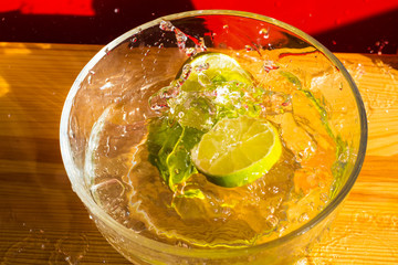 Laim in a plate with water and drops, spray