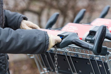 Ein Chip wird mit Handschuhen in den Einkaufwagen geschoben
