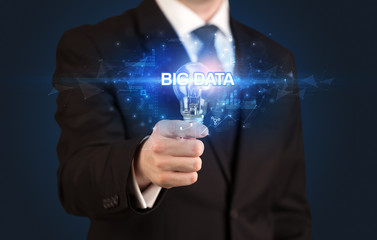 Businessman holding light bulb with BIG DATA inscription, innovative technology concept