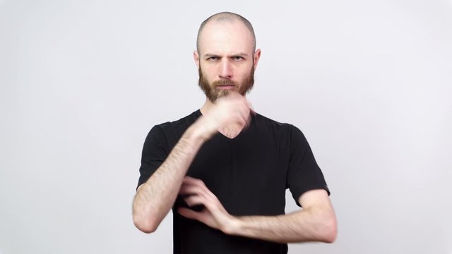Strict man raising finger in warning gesture over white background. Serious dissatisfied man making admonishing gesture, disapproval sign, saying no.