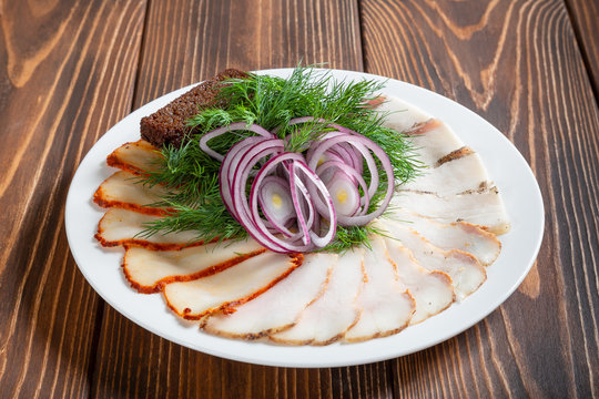 Cold appetizers. Bacon-fat with russian toasts of black bread called grenki and red onion