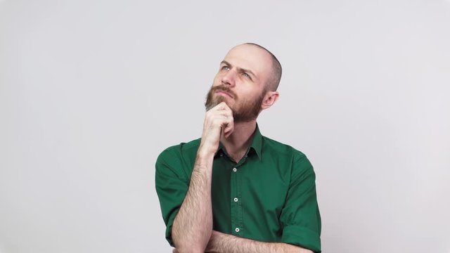 Portrait of serious bearded man thinking or remembering, isolated over white background. Clever creative man gets an idea. Concept of emotions.
