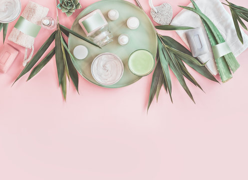 Modern beauty and skin care. Various natural cosmetic products with bamboo branches and aloe vera leaves. Eco friendly body care and spa accessories on pastel pink background. Zero waste . Top view