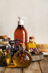 Assortment of natural oils in glass bottles on wooden background. Concept of pure organic ingredients in cosmetology. Atmosphere of harmony, relax, spa. Close up macro. Copy space for text

