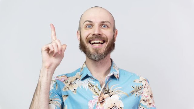 Portrait of a man wearing hawaiian shirt thinking or remembering, isolated over white background. Clever creative man gets an idea. Concept of emotions.
