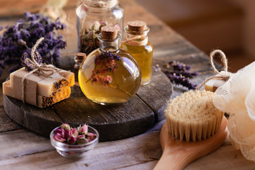 Obraz na płótnie Canvas Concept of natural organic oil in cosmetology. Moisturizing skin care and aromatherapy. Gentle body treatment. Handmade soap. Atmosphere of harmony relax. Wooden background, lavender flower copy space