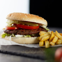Tasty burger with tomatoes and lettuce