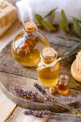 Concept of natural organic oil in cosmetology. Moisturizing skin care and aromatherapy. Gentle body treatment. Handmade soap. Atmosphere of harmony, relax. Wooden background, lavender flowers