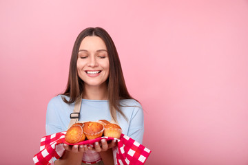 Young woman in apron is standing by yellow background