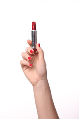 Hand with red manicure with red lipstick in hands isolated on white background