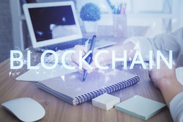 Cryptocurrency hologram over hands taking notes background. Concept of blockchain. Multi exposure