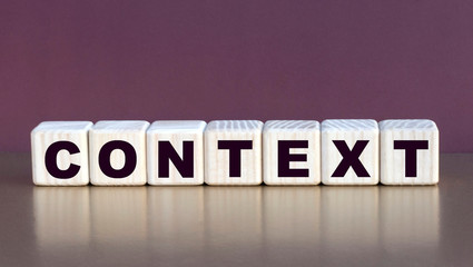 Fototapeta premium CONTEXT word on cubes on a burgundy background