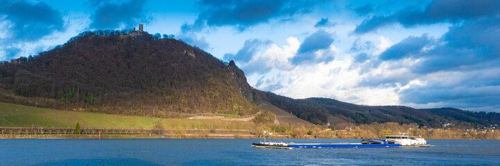 Fototapeta na wymiar GERMANY, BONN. A cargo ship navigating the Rhine river below castle Drachenfels