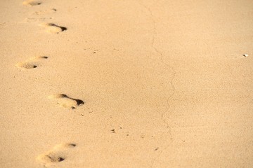Fototapeta na wymiar Rastro de pies en la arena de la playa