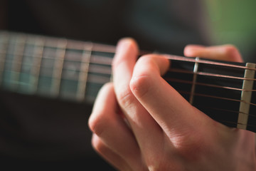 Young man playing on acoustic guitar