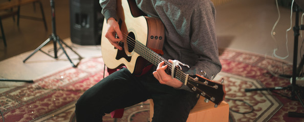 Fototapeta na wymiar Young man playing on acoustic guitar