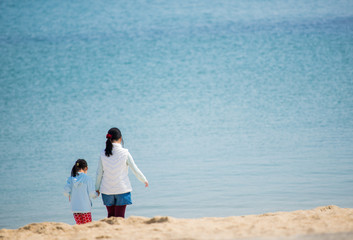 初夏の海水浴場で遊んでいる子供姉妹