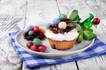 Easter cupcake topped with multicolored marzipan eggs, chocolate nest and marshmallow creme