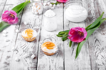 Cupcakes topped with caramelized marshmallow creme icing on the white wooden table