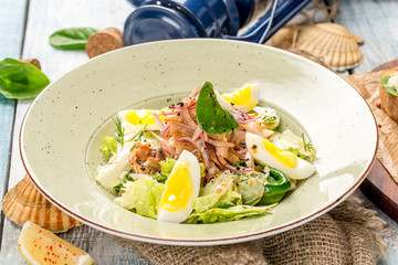 Salad with egg, meat, fresh herbs in a plate