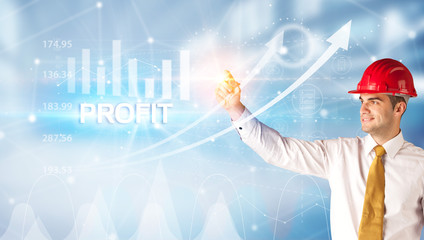 Young businessman with helmet drawing PROFIT inscription, modern business technology concept