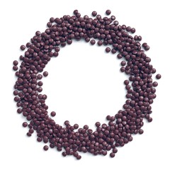 Chocolate coated candies arranged in circle frame on white background