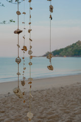 Decorations made of sea stones and shells against the background of sea shore in the morning