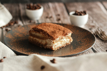 Tiramisu cake on a plate. Romantic composition with coffee and other elements