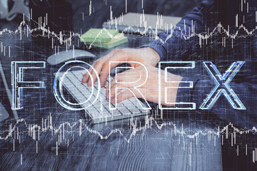 Stock graph with businessman typing on computer in office on background. Concept of analysis. Double exposure.