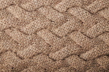 knitted carpet close -up. Textile texture on a white background. Detailed warm yarn background. Knit cashmere beige wool. Natural wool fabric, a fragment of a sweater.