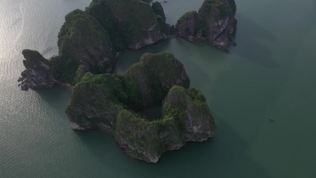 Aerial view of royalty high quality free stock footage over natural rocks green tops Halong bay, Ba Hang floating fishing village, sea blue azure water. Wild natural untouched seascape. Asia, Vietnam