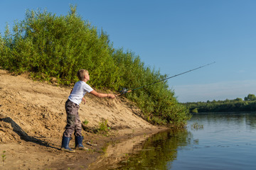 Fototapeta na wymiar Photo of a young boy fishing outdoors on a summer day.