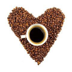 Cup of coffee and a heart shape made of roasted coffee beans isolated on a white background. Top view. Flat lay