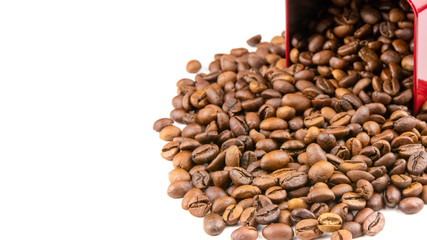 Roasted coffee beans spilling out of a metal box isolated on a white background