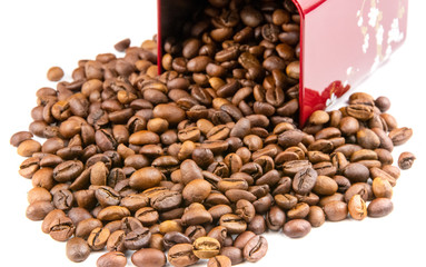 Roasted coffee beans spilling out of a metal box isolated on a white background