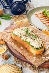 Sandwich with pate and fresh salad on paper and blackboard