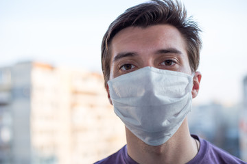 A young guy of European looking wears a medecine mask