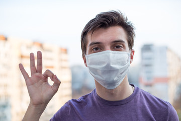A young guy of European looking wears a medecine mask