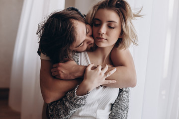 the man hugs the girl and kisses her on the cheek