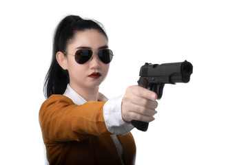 Portrait beautiful asia woman wearing a yellow suit one hand holding a pistol gun at white background, Young sexy girl long hair with a handgun, Pretty women stands with a pistol