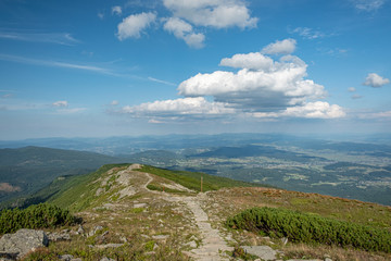 A tourist path on the top a mountain with an open view over hills and valleys