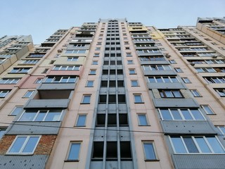 Symmetric facade of old soviet multistorey typical concrete apartment.