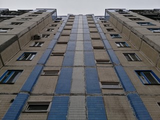 Symmetric facade of old soviet multistorey typical concrete apartment.