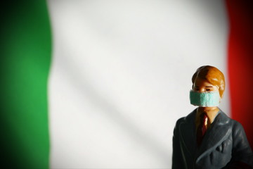 Miniature figure businessman model wearing mask and flag background scene.