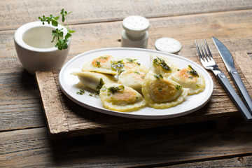 Fried dumplings with herbs on wood.