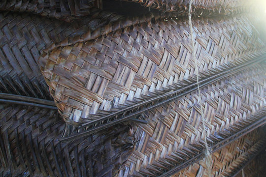 A beach fale is a simple thatched hut in Samoa. They are using the weaved coconut leaves as a blind or curtain cover for the room.