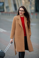 Obraz premium Full body side portrait of business woman walking with suitcase in terminal