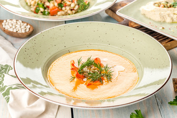 Several dishes of pumpkin soup, salad and sandwich