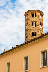 Fototapeta na wymiar Bell tower of Basilica of Sant'Apollinare Nuovo in Ravenna, Province of Ravenna, Region of Emilia-Romagna, Italy as seen behind a building