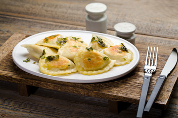 Fried dumplings with herbs on wood.